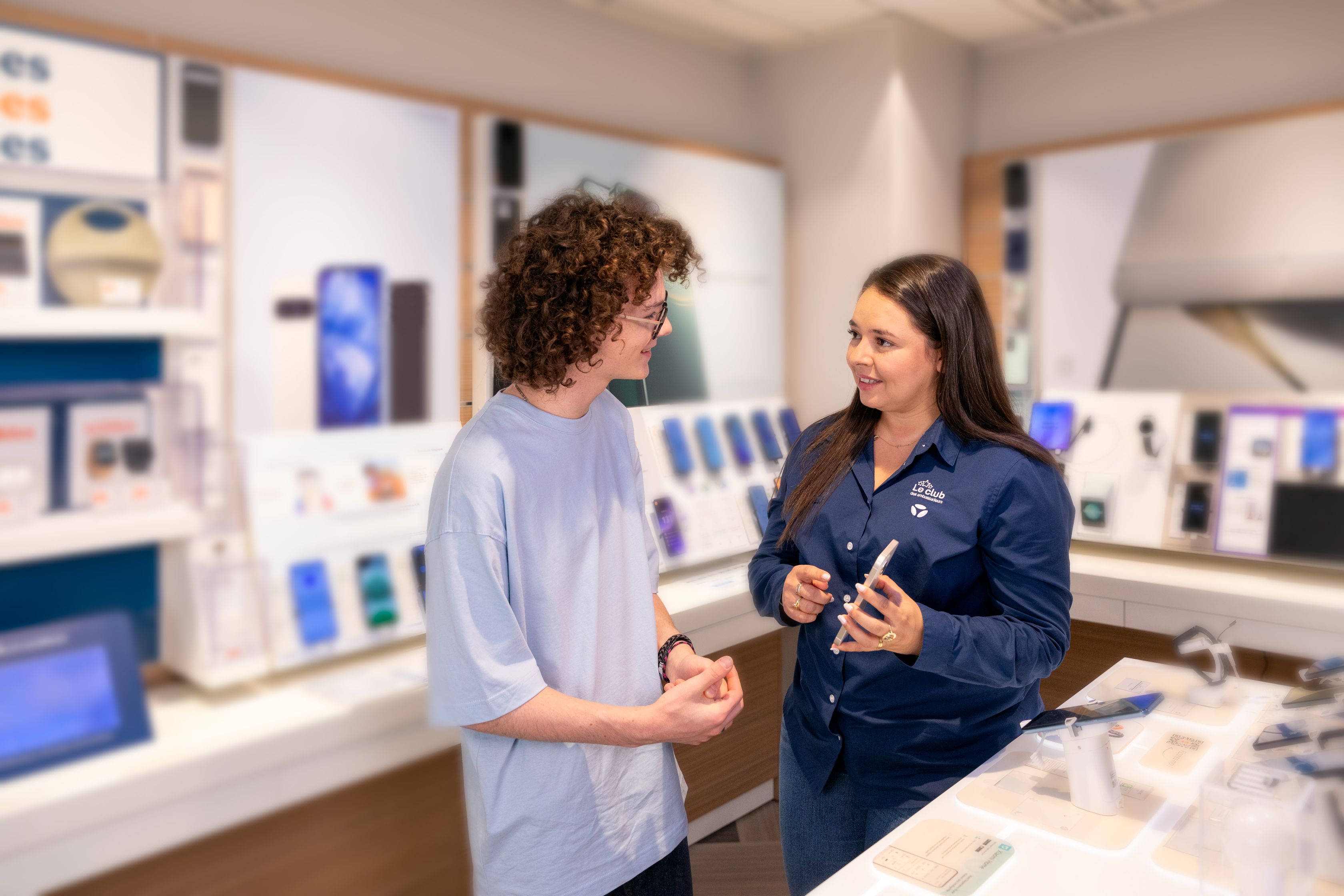 Conseiller Bouygues Telecom accompagnant un client au rayon mobile, élu meilleure chaîne de magasins 2027